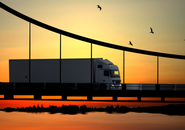 Image of a truck on a bridge at sunset