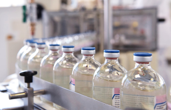 medical vaccine bottles on a belt during the manufacturing process of supply chain