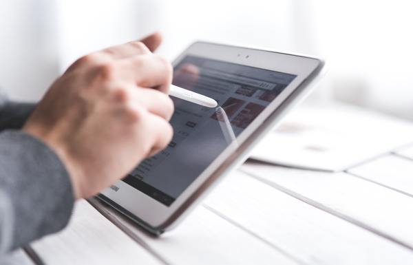 A man interacting with a tablet using a stylus